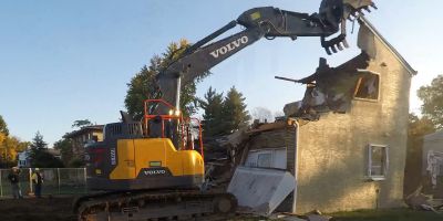 An excavator removes the top of a house in Upper Arlington